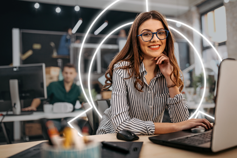 young professional woman at laptop facing camera