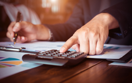 man at desk with calculator