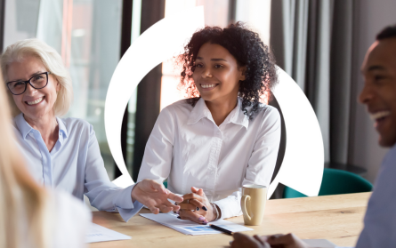 woman-smiling-at-conference-table-with-others-and-credit-hero-halo