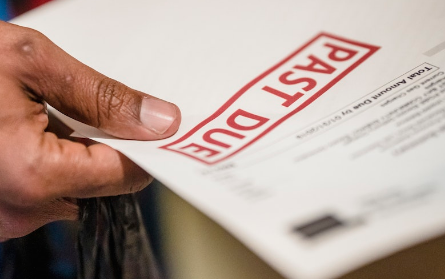 hand holding document with past due stamp