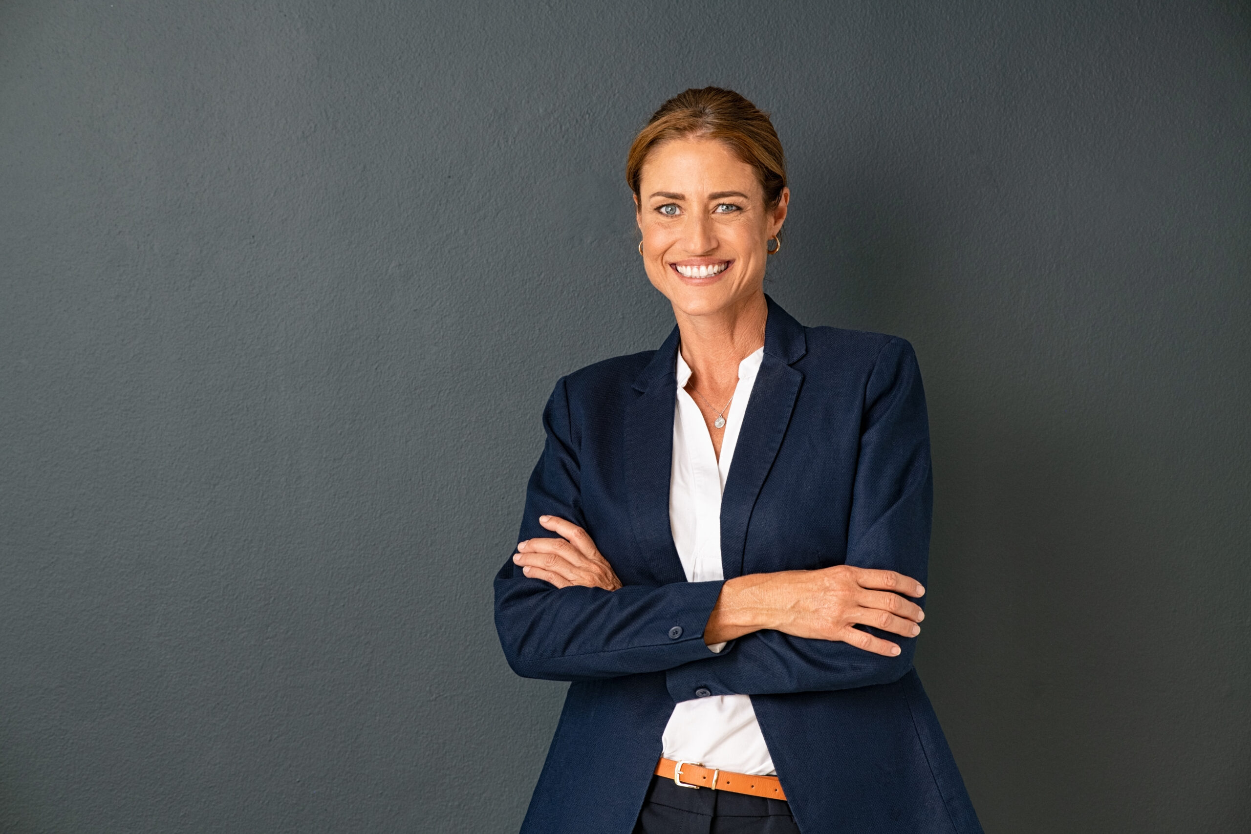 business woman standing confidently against grey background