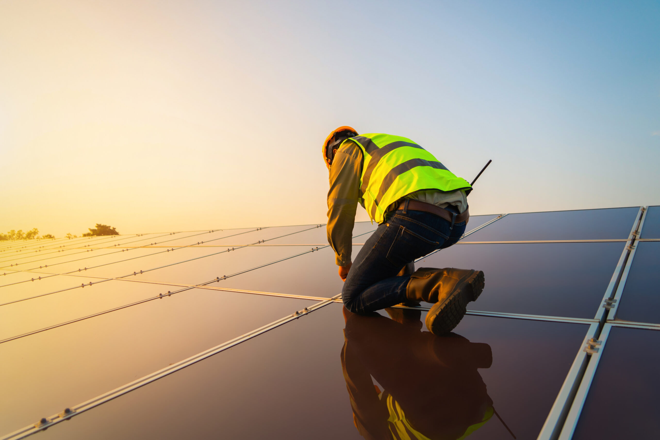 engineer man or worker, people, with solar panels or solar cells on the roof in farm. Power plant with green field, renewable energy source in Thailand. Eco technology for electric power.