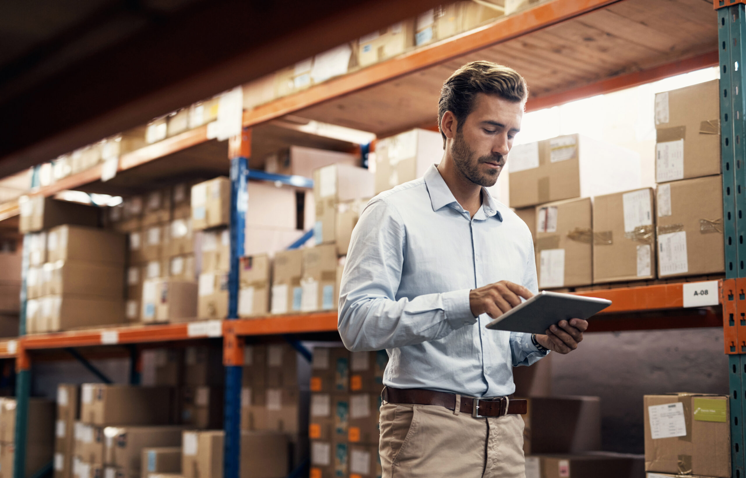 young man using a digital tablet while working in a warehouse